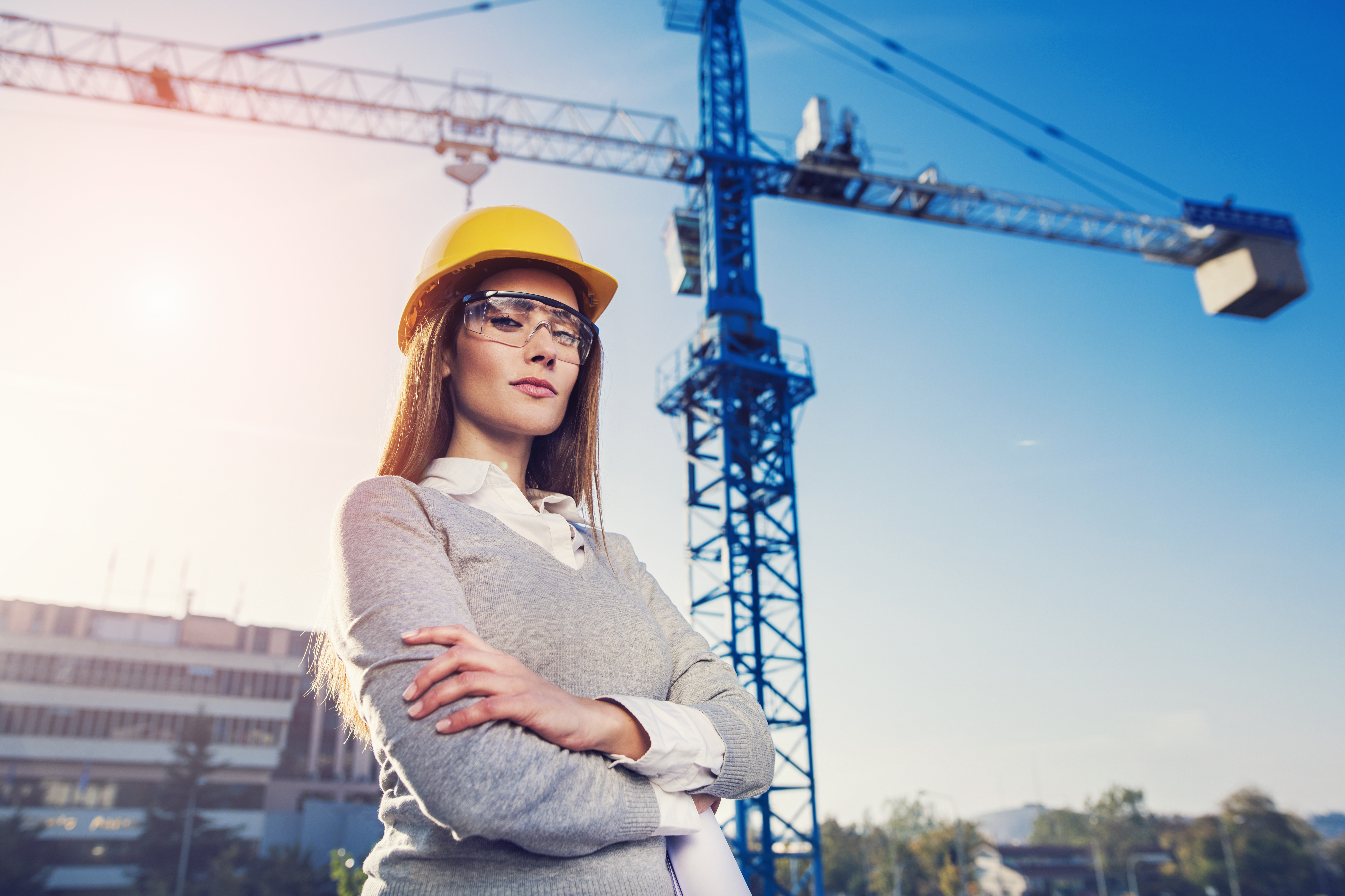 photo of female contractor with crane in the background
