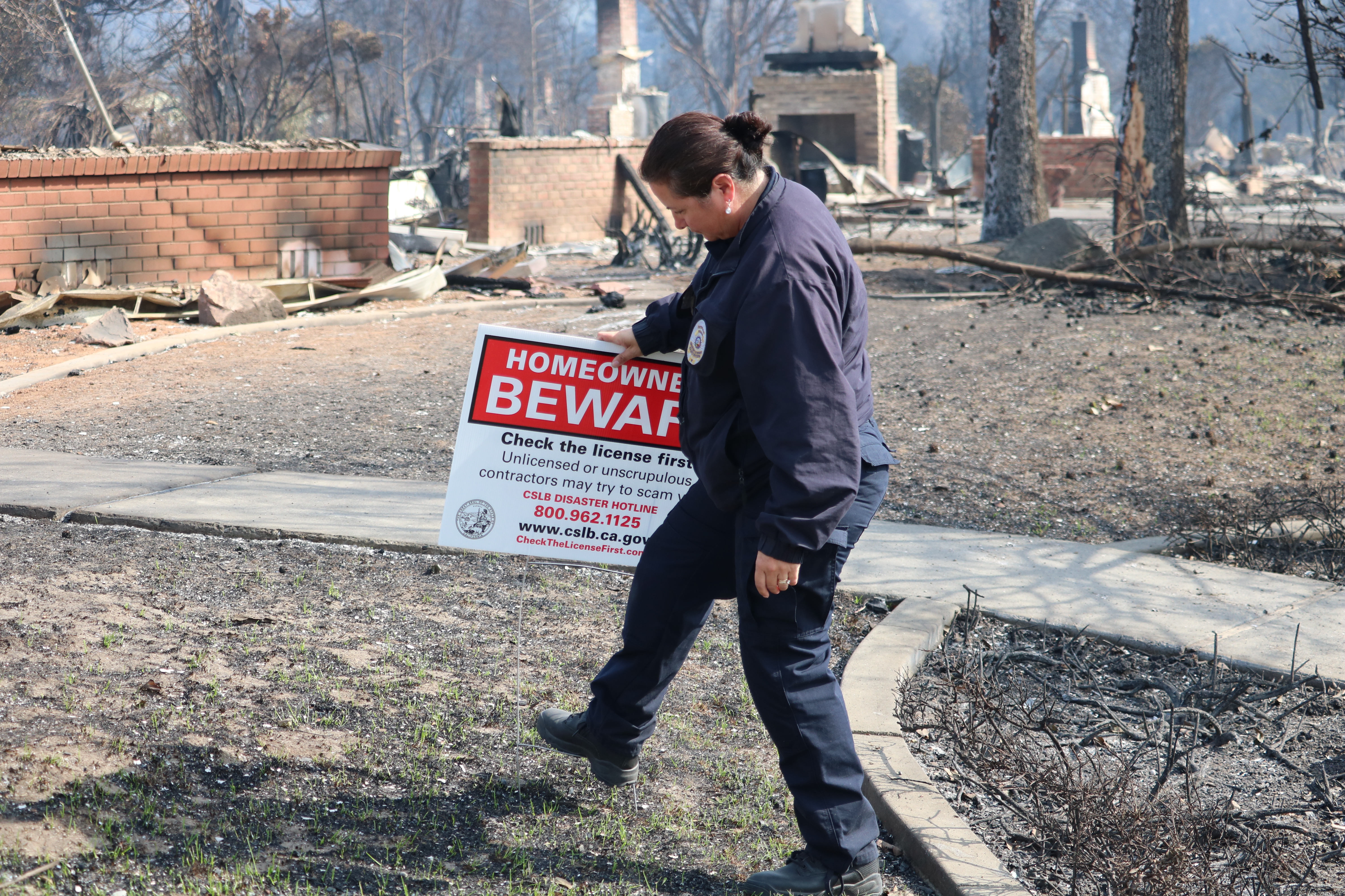 Image of inspector posting sign on site